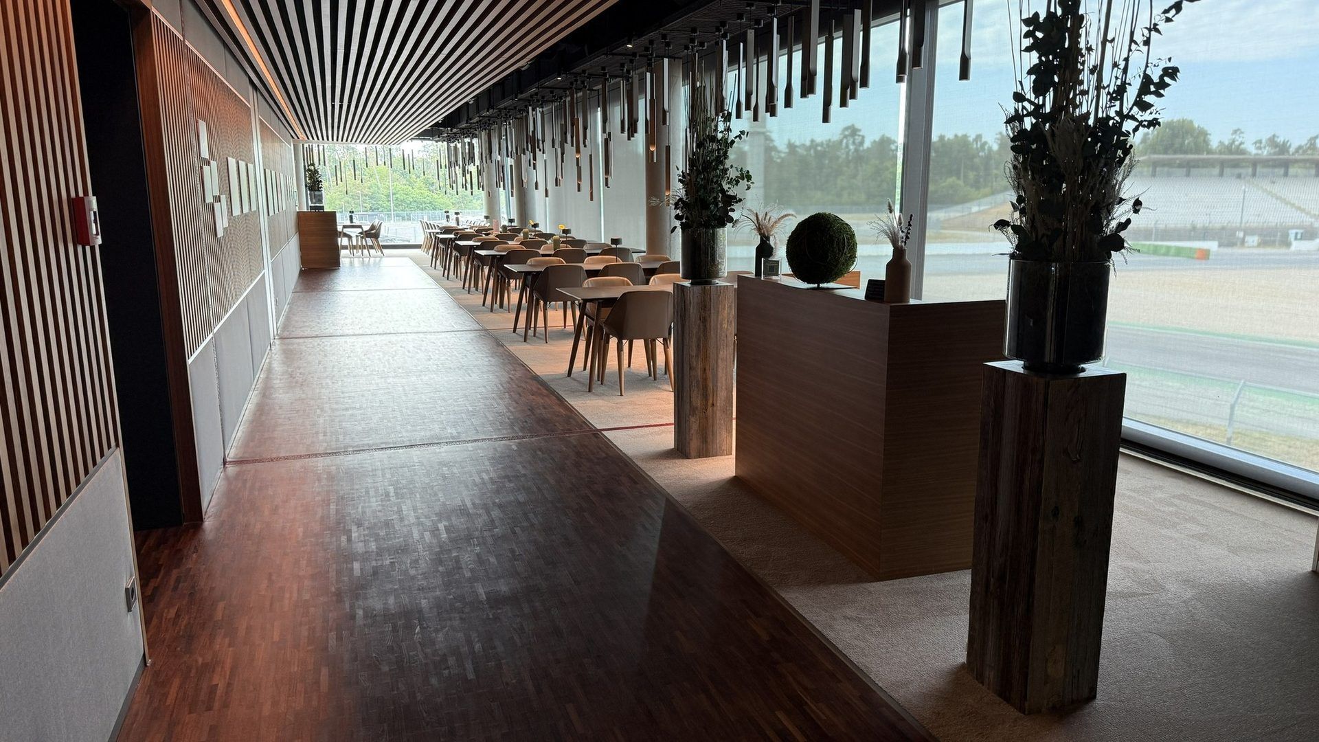 Lounge mit gedeckten Tischen und Panoramablick auf die Rennstrecke